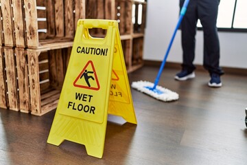 person mopping and wet floor sign